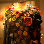 Aufnahme eines Pullovers aus der Ausstellung Ugly Sweater, der mit verschiedenen Textilresten ausgestattet ist